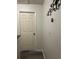 Bright hallway with dark laminate flooring, white door, and modern thermostat at 707 Carpenters Way # 50, Lakeland, FL 33809