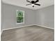 A clean and bright bedroom with a ceiling fan, large window, and hardwood floors at 809 Deer Glen Ct, Fruitland Park, FL 34731