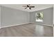 A neutral bedroom features a fan, hard wood floors and a bright window view at 809 Deer Glen Ct, Fruitland Park, FL 34731