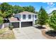 Two-story home boasts a three-car garage, crisp white paint, and contrasted black trim at 809 Deer Glen Ct, Fruitland Park, FL 34731