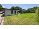 View of lush backyard featuring home and screened pool area with blue skies at 8655 Shady Glen Dr, Orlando, FL 32819