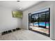 Bright workout room opens to screened pool with dumbbells and mounted television at 8655 Shady Glen Dr, Orlando, FL 32819