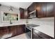 Dark wooden cabinets, stainless steel appliances, and white countertops in the kitchen at 8655 Shady Glen Dr, Orlando, FL 32819