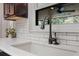 Close up of the kitchen sink, white subway tile backsplash and view to the lanai at 8655 Shady Glen Dr, Orlando, FL 32819