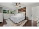Inviting main bedroom with a rustic accent wall, hardwood floors and a sun-filled window at 8655 Shady Glen Dr, Orlando, FL 32819