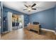 Bright office space featuring a ceiling fan, a large desk, and sliding glass doors leading to the pool area at 8655 Shady Glen Dr, Orlando, FL 32819