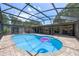 Wide angle shot of enclosed in-ground pool surrounded by brick pavers and an entertainment area at 8655 Shady Glen Dr, Orlando, FL 32819