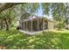 Lush backyard featuring a large screened-in lanai, perfect for relaxing and entertaining at 9644 Myrtle Creek Ln, Orlando, FL 32832