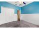 Comfortable bedroom featuring blue accent wall with modern ceiling fan, closet and plush carpet at 9644 Myrtle Creek Ln, Orlando, FL 32832