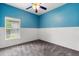 Comfortable bedroom featuring blue accent wall with modern ceiling fan, window, and plush carpet at 9644 Myrtle Creek Ln, Orlando, FL 32832