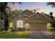 Charming single-story home featuring a two-car garage, well-manicured lawn, and colorful landscaping at 9644 Myrtle Creek Ln, Orlando, FL 32832