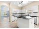Bright kitchen featuring an island, white cabinets, black countertops and stainless-steel appliances at 9644 Myrtle Creek Ln, Orlando, FL 32832