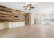 Open-concept living space with modern wood accent wall, tile flooring, and views of kitchen at 9644 Myrtle Creek Ln, Orlando, FL 32832