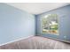 Bright living room with soft carpet and a large window letting in natural light and neighborhood views at 9644 Myrtle Creek Ln, Orlando, FL 32832