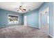 Large main bedroom featuring a ceiling fan, carpet flooring, and a large window at 9644 Myrtle Creek Ln, Orlando, FL 32832