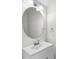 Clean bathroom featuring a vanity with a sink, modern faucet, round mirror, and white color scheme at 10914 Savannah Wood Dr # 139, Orlando, FL 32832