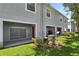 Exterior view of home featuring sliding glass doors, a patio area, manicured lawns, and mature trees at 10914 Savannah Wood Dr # 139, Orlando, FL 32832