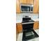 Modern stainless steel oven and microwave above with wooden cabinets and light countertops, ready for cooking at 10914 Savannah Wood Dr # 139, Orlando, FL 32832