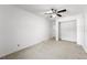 Bright bedroom featuring a ceiling fan, neutral carpeting, and an open closet at 1189 Rib Ave, St Cloud, FL 34771