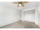 Simple carpeted bedroom with an open closet space and ceiling fan at 1189 Rib Ave, St Cloud, FL 34771