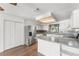 Updated kitchen with stainless steel refrigerator, white cabinets, and breakfast bar area at 1189 Rib Ave, St Cloud, FL 34771