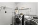 Practical laundry area with washer, dryer, and shelving for storage solutions at 1189 Rib Ave, St Cloud, FL 34771