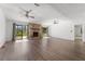 Open living room with fireplace, wood floors, ceiling fans, and views to the yard at 1189 Rib Ave, St Cloud, FL 34771