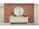 Staged entryway featuring a round mirror, neutral console table, and minimalist decor at 1277 Deepwater Cir, Eagle Lake, FL 33839