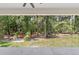 Back porch and lush green yard with mature trees and landscaping at 1394 Kettledrum Trl, Deltona, FL 32725