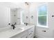 Bright modern bathroom with dual sinks, quartz countertops and black fixtures, frosted window, ample natural light at 1394 Kettledrum Trl, Deltona, FL 32725