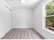 Bright bedroom with neutral carpet, a window overlooking a green landscape, and sliding door closet at 1394 Kettledrum Trl, Deltona, FL 32725