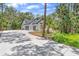 A long, curved driveway leading to a white home with a two-car garage surrounded by trees at 1394 Kettledrum Trl, Deltona, FL 32725