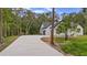A long, winding driveway leading to a modern white house with a two-car garage at 1394 Kettledrum Trl, Deltona, FL 32725