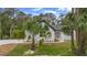 A modern white home with black trim and a well-manicured lawn with palm trees at 1394 Kettledrum Trl, Deltona, FL 32725
