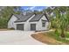 Side view of a modern two-car garage with gray doors and exterior lighting fixtures at 1394 Kettledrum Trl, Deltona, FL 32725