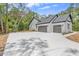 Spacious two-car garage with gray doors, exterior lights, and a long concrete driveway at 1394 Kettledrum Trl, Deltona, FL 32725