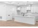 Modern white kitchen with an island, stainless steel appliances, and ample cabinet space at 1394 Kettledrum Trl, Deltona, FL 32725
