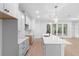 Well-lit kitchen featuring white cabinets, stone countertops, and access to the outdoors at 1394 Kettledrum Trl, Deltona, FL 32725