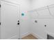 A bright laundry room with white walls, wood floor, a wire shelf, and utility connections at 1394 Kettledrum Trl, Deltona, FL 32725