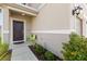 Inviting front entrance showcasing a dark brown door, neutral facade, and vibrant landscaping at 1401 Mirabella Cir, Davenport, FL 33897