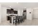 Modern kitchen featuring dark cabinets, granite countertops, a stainless steel refrigerator, and an island at 1401 Mirabella Cir, Davenport, FL 33897