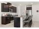 Modern kitchen with dark cabinets, granite countertops, stainless steel appliances, and island seating for four at 1401 Mirabella Cir, Davenport, FL 33897