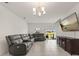 Comfortable living room with a large sectional sofa, tiled floors, modern lighting, and backyard access at 1401 Mirabella Cir, Davenport, FL 33897