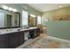 Bathroom featuring dual vanities, a walk-in shower, and a decorative turtle rug at 14830 Winkfield Ct, Winter Garden, FL 34787