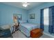 Inviting bedroom with blue accents, comfortable bed, and study area near window at 14830 Winkfield Ct, Winter Garden, FL 34787