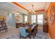 Open dining room with a dining table, modern chandelier, and a view into the entry and other living spaces at 14830 Winkfield Ct, Winter Garden, FL 34787