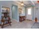 Inviting entryway with tile flooring, soft blue walls, stylish console table, decorative shelving, and lots of natural light at 14830 Winkfield Ct, Winter Garden, FL 34787