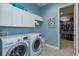 Laundry room is equipped with a washer, dryer, storage cabinets, and a convenient folding area at 14830 Winkfield Ct, Winter Garden, FL 34787