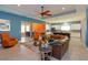 Open-concept living room with leather sectional, modern furnishings, and a seamless flow into the kitchen and dining areas at 14830 Winkfield Ct, Winter Garden, FL 34787