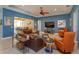 Bright living room features stylish seating, a modern ceiling fan, and sliding glass doors to the outdoor patio at 14830 Winkfield Ct, Winter Garden, FL 34787